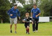 23 August 2012; Ava Lillis, age 7, gets away from Leinster's Rob Kearney, left, and Jonathan Sexton during the VW Leinster Rugby Summer Camps at De La Salle Palmerston RFC. De La Salle Palmerston RFC, Kilternan,  Co. Dublin. Picture credit: Pat Murphy / SPORTSFILE