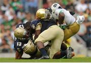 1 September 2012; KeiVarae Russell, Notre Dame, is tackled by Jordan Drake, 13, and Quincy Adams, Navy. NCAA Emerald Isle Classic, Navy v Notre Dame, Aviva Stadium, Lansdowne Road, Dublin. Picture credit: Pat Murphy / SPORTSFILE