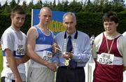 27th July 2002; Winner of the U.17 Shot Putt Brendan Callinan, St Laurence O'Toole AC,  Carlow, is presented with the Gold Medal by AAI President Michael Heery in the company of runner-up Padraig White, Dunboyne left, and Justin Collins, Mullingar Harriers, right, at theLucozade Sport AAI Juvenile Track & Field Championship of Ireland 2002, Tullamore Harriers Stadium, Tullamore, Co. Offaly. Athletics. Picture credit; Ray McManus / SPORTSFILE *EDI*