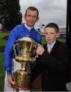 15 September 2012; Jockey Kevin Manning with his son James after winning the Goffs Vincent O'Brien Stakes aboard Dawn Approach. Curragh Racecourse, the Curragh, Co. Kildare. Photo by Sportsfile
