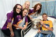 17 September 2012; Benjiman Kikkers, from Killaloe, Co. Clare, holds the O'Duffy Cup alongside members of the Wexford team, from left, Louise O'Leary, Frances Doran, Helena Jabob and Louse Codd during a visit to Our Lady's Hospital for Sick Children, Crumlin, Dublin. Picture credit: David Maher / SPORTSFILE