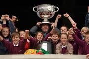 20 September 2012; Pupils from Gaelscoil Thulach na nÓg, Dunboyne, Co. Meath, with teacher Adrian Ó Dúill, who were on a school tour to Croke Park, get their hands on The Sam Maguire Cup with the official Donegal and Mayo match jerseys ahead of the GAA Football All-Ireland Senior Championship final between Donegal and Mayo in Croke Park, on Sunday. Croke Park, Dublin. Picture credit: Stephen McCarthy / SPORTSFILE