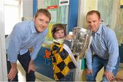 1 October 2012; Luc Carey, aged 9, from Stoneybatter, Co. Dublin, lifts the Liam MacCarthy Cup alongside Kilkenny's Aidan Fogarty, left, and Tommy Walsh during a visit to Our Lady's Hospital for Sick Children, Crumlin, Dublin. Picture credit: Barry Cregg / SPORTSFILE