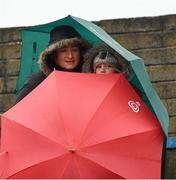 28 October 2012; St Patrick's' supporters Triona Keogh and her daughter Kayleigh, age 7, from Wicklow Town, shelter from the prevailing conditions before the game. AIB Leinster GAA Football Senior Club Championship, First Round, St Patrick's v Éire Óg, County Grounds, Aughrim, Co. Wicklow. Picture credit: Ray McManus / SPORTSFILE