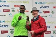 29 October 2012; Third placed athlete in the elite men's race Abdisa Bedala, Ethiopia, is presented with his award by Alex Sweeney, Chairman of the BHAA and the Dublin Marathon, after the Dublin Marathon 2012. Merrion Square, Dublin. Picture credit: Brendan Moran / SPORTSFILE