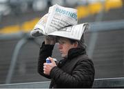 18 November 2012; A supporter covers himself from the rain. Galway County Senior Hurling Championship Final, Loughrea v St. Thomas, Pearse Stadium, Galway. Picture credit: Ray Ryan / SPORTSFILE
