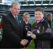 27 November 2012; Matthew Ryder, Terenure College, receives his Corn Mhic Chaoilte winners medal from Liam Ó Néill, Uachtarán, Chumann Lúthchleas Gael after the game. Allianz Cumann na mBunscol Finals, Terenure Junior School v Divine Word Marley, Croke Park, Dublin. Picture credit: Ray McManus / SPORTSFILE