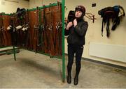 4 December 2012; Jockey Nina Carberry ties up her helmet in the tack room during a yard visit ahead of the launch of the Leopardstown Christmas Festival. Ta Vu Stables, Castletown, Navan, Co Meath. Picture credit: David Maher / SPORTSFILE