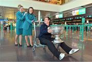 31 January 2013; Aer Lingus flight attendants Grainne Kelly, left, and Orla Kelly with Tyrone footballer Brian McGuigan, holding the Sam Maguire Cup, prior to his departure to Breezy Point in New York today as part of a GPA work party where they will assist with the reconstruction of the local youth sports facilities destroyed during Hurricane Sandy. The party is travelling with the support of Aer Lingus. Dublin Airport, Dublin. Picture credit: Barry Cregg / SPORTSFILE