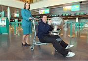 31 January 2013; Aer Lingus flight attendant Orla Kelly and Tyrone footballer Brian McGuigan, holding the Sam Maguire Cup, prior to his departure to Breezy Point in New York today as part of a GPA work party where they will assist with the reconstruction of the local youth sports facilities destroyed during Hurricane Sandy. The party is travelling with the support of Aer Lingus. Dublin Airport, Dublin. Picture credit: Barry Cregg / SPORTSFILE