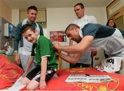 5 June 2013; Republic of Ireland's Richard Dunne and Robbie Keane look on as Jonathan Walters signs the jersey of Cody Nolan, age 8, from Carlow, during a visit to Our Lady's Children's Hospital. Our Lady's Children's Hospital, Crumlin, Dublin. Picture credit: David Maher / SPORTSFILE
