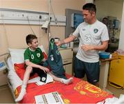 5 June 2013; Republic of Ireland's Robbie Keane hands Cody Nolan, age 8, from Carlow, his training top during a visit to Our Lady's Children's Hospital. Our Lady's Children's Hospital, Crumlin, Dublin. Picture credit: David Maher / SPORTSFILE