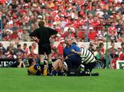 4 July 1999; Clare's Ollie Baker receives medical attention from an ankle injury. Cork v Clare, Munster Hurling Final, Semple Stadium, Thurles. Picture credit; Brendan Moran/SPORTSFILE
